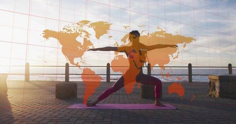 Practicing sunrise warrior ii yoga on seafront promenade with world map overlay