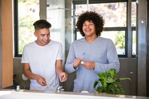 Diverse Friends Practicing Dental Hygiene at Modern Bathroom Sink