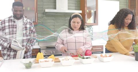 Group Preparing Healthy Meal on Modern Kitchen Island Chopping Red Pepper and Herbs