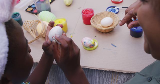 Happy african american grandmother and granddaughter painting easter eggs - Download Free Stock Photos Pikwizard.com