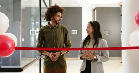 Diverse business colleagues at opening ceremony with red ribbon
