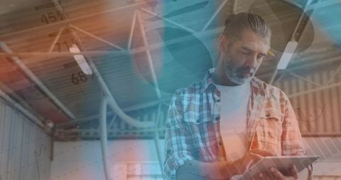 Businessman Analyzing Data on Tablet Device in Industrial Warehouse