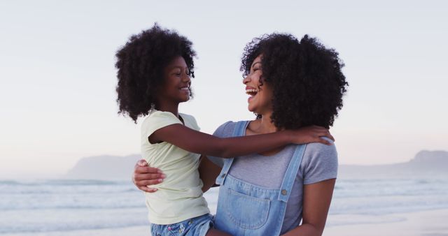 Portrait of african american mother and daughter smiling together at the beach. family travel vacation leisure concept