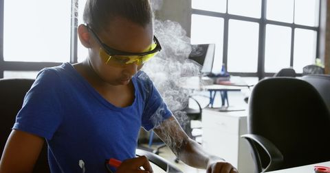 young girl adorning protective goggles while soldering circuit - Download Free Stock Images Pikwizard.com