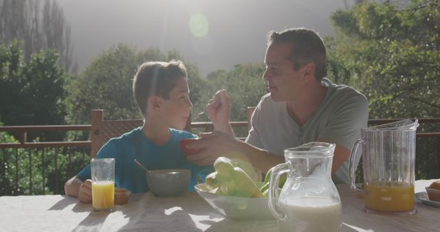 Father and son enjoying breakfast outdoors in sunny morning - Download Free Stock Images Pikwizard.com