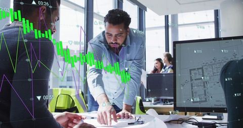 Team analyzing real-time financial charts alongside floor plans in bright modern open office
