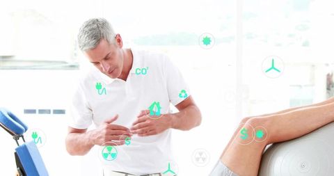 Therapist examining patient's leg using exercise ball in modern clinic