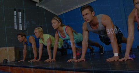 Group holding plank on raised gym platform, training core strength and endurance