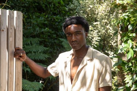 African American Man Opens Garden Gate in Tranquil Backyard