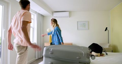 Couple preparing for travel with packing in modern bedroom