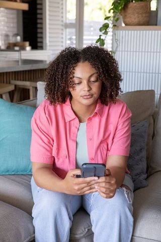 Relaxed Woman Checking Smartphone in Cozy Living Room
