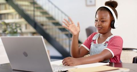 Young Girl Engaging in Online Learning with Headphones