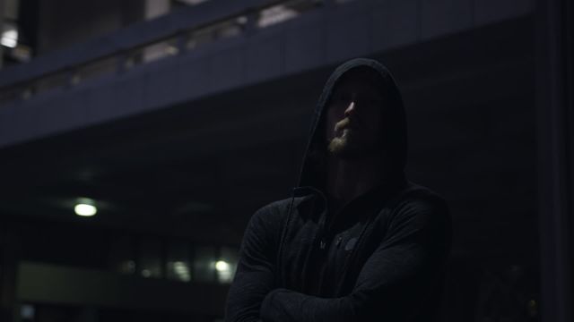 This video depicts a young athletic man crossing his arms while wearing a hoodie in an urban park at night. Ideal for promoting healthy lifestyles, fitness, urban activities, and evening workouts. Perfect for use in fitness blogs, articles on urban sports, or advertisements related to athletic wear and nighttime exercise routines.