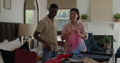 Couple joyfully packing suitcase for travel