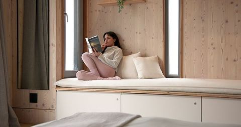 Woman enjoying quiet reading time in cozy wooden room