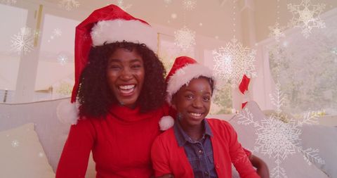 Joyful Mother and Daughter in Santa Hats Celebrating Christmas