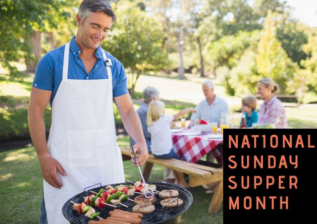 Family gathered outdoors for a National Sunday Supper Month celebration, enjoying barbecue in a sunny park. A man in an apron grills food such as skewers and hotdogs while family members, spanning multiple generations, sit at a picnic table in the background. Ideal for promotions involving family events, outdoor activities, food-related content, and celebrating national observation days.