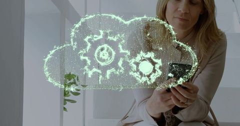 Executive Using Smartphone Visualizing Cloud Computing Gears Hologram in Office