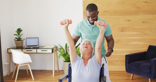 Senior woman in a wheelchair exercising with a caregiver's assistance. At-home physical therapy promoting fitness and rehabilitation for elderly individuals. Useful for healthcare, wellness, and elderly care-related content.