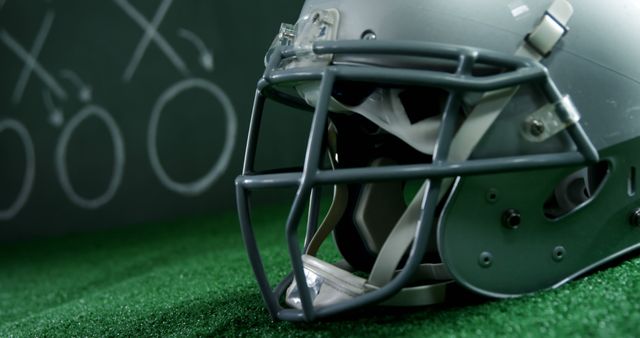 American Football Helmet on Green Grass Indoor Field with Strategy Board - Download Free Stock Images Pikwizard.com