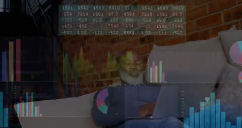 Senior Man Analyzing Data with Laptop and Digital Charts in Loft Workspace
