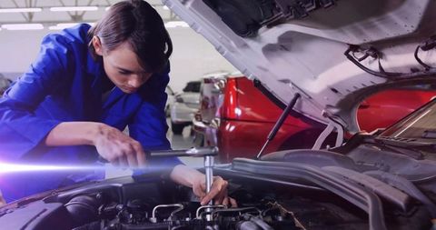 Female Auto Technician Adjusting Car Engine in Garage