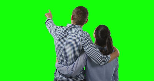 Rear View of Couple Embracing and Pointing Against Green Screen Background - Download Free Stock Images Pikwizard.com