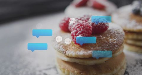 Stacking pancakes dusting powdered sugar and topping raspberries with chat bubble overlay