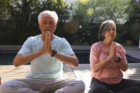 Senior Couple Meditating Beside Pool for Relaxation and Mindfulness