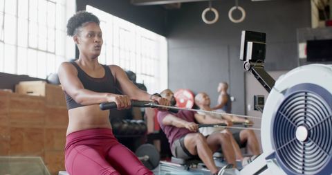 Focused African American Woman Using Rowing Machine at Gym