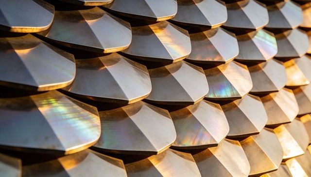 Overlapping metallic scales with iridescent highlights and beveled geometry