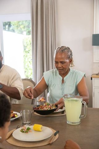 Senior Woman Serving Salad at Family Lunch Gathering