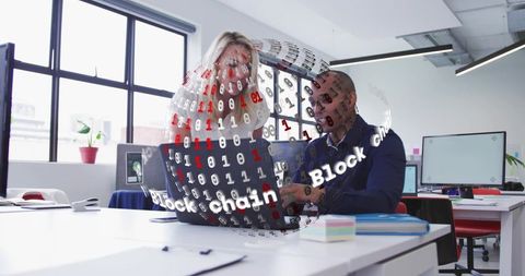 Collaborating professionals exploring blockchain hologram over laptop in modern office