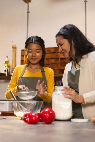 Mother and Daughter Baking Together in Cozy Kitchen Setting