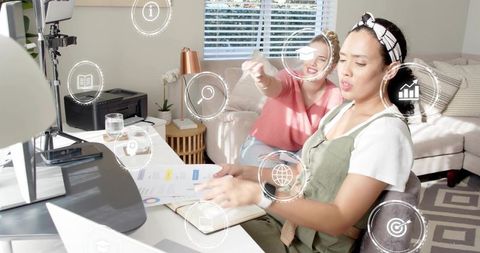Collaborating in home office turning pages and using floating ui icons for remote workflow