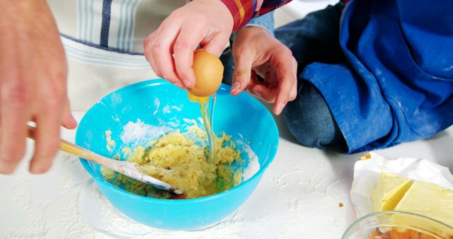 Child and adult mixing dough in blue bowl together. Encourages family bonding, teamwork, and cooking skills. Ideal for illustrating family activities, kitchen fun, parent-child interactions, and home cooking themes.