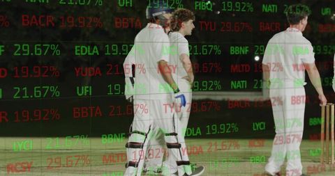 Floodlit cricket players walking on night pitch with financial ticker double exposure