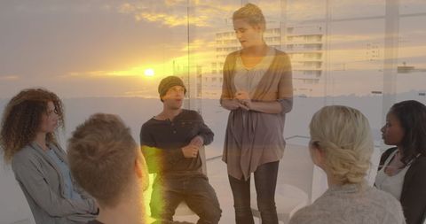 Diverse group engaged in therapy session over serene sunset