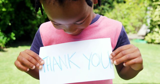 Child Holding 'Thank You' Sign in Garden - Download Free Stock Images Pikwizard.com