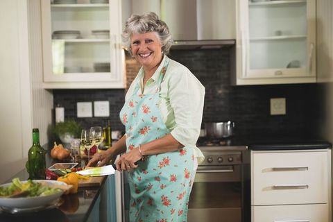 Senior Woman Joyfully Cooking at Home Kitchen