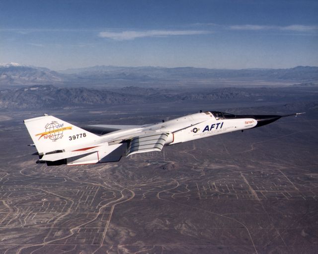 This image showcases a modified General Dynamics AFTI/F-111A Aardvark during flight, featuring Boeing's mission adaptive wing (MAW) technology. The aircraft soars over a desert landscape, highlighting advanced supercritical wing performance integrated through the collaborative efforts of NASA and the Air Force in the early 1980s. Suitable for depicting historical aviation advancements, military aircraft studies, aerospace technology, and collaborative aerospace projects.