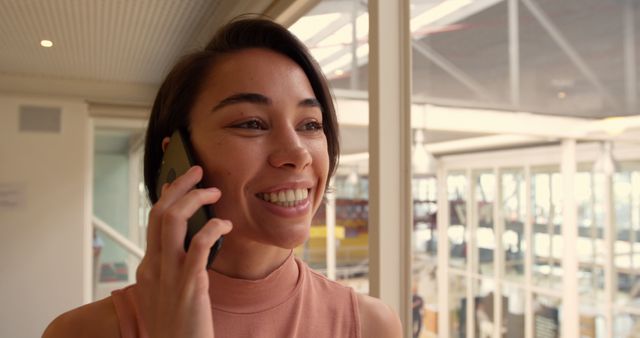 Smiling Woman Having a Phone Conversation in Modern Office - Download Free Stock Images Pikwizard.com