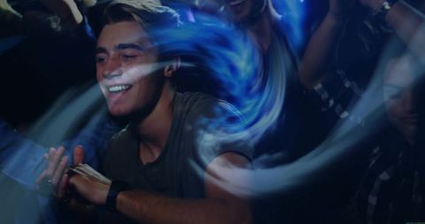 Energetic Man Dancing with Light Trails in Night Club