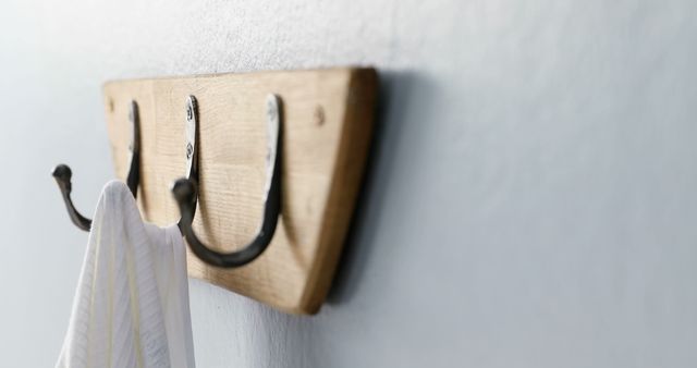 Capture rustic charm with a simple wooden wall hook and towel, ideal for farmhouse-style bathroom decor. Great for blogs on interior design, home decor inspiration, and sustainable living.