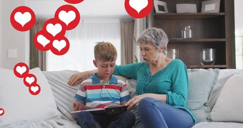 Caucasian Grandmother Reading Book with Grandson at Home