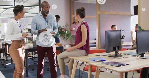 Diverse team collaborating with digital media icons in modern office