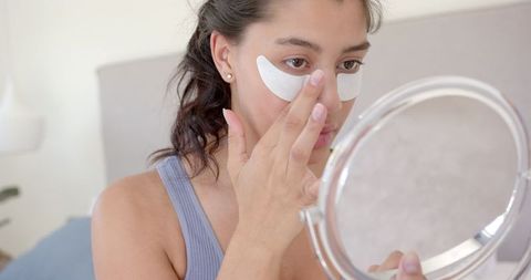 Teen girl applying eye masks for skincare routine