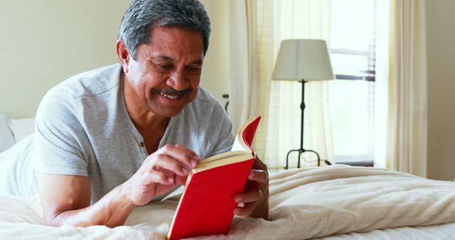 Older Man Reading a Book on Bed in Cozy Bedroom - Download Free Stock Images Pikwizard.com