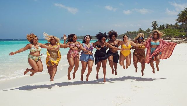 Joyful plus-size women jumping on tropical beach holding hands in colorful swimwear