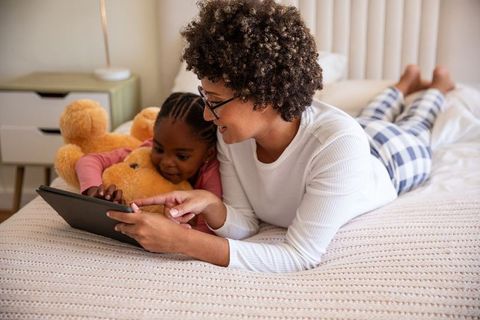 African American Mother and Daughter Relaxing with Tablet